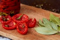 Dried red tomatoes with spices and herbs on wooden board Royalty Free Stock Photo