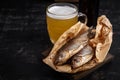 Dried roach fish and glass of beer on dark table, close up Royalty Free Stock Photo