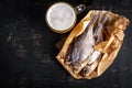Dried roach fish and glass of beer on dark table, flat lay Royalty Free Stock Photo
