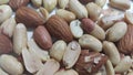 Dried and roasted peanuts and almonds out of shell. A fruit for background