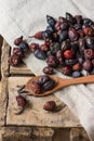 Dried rose hips scattered on wood background over linen cloth, spoon with fruits Royalty Free Stock Photo