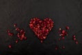 Dried Rose Petals in heart shape on dark stone background. Design element. Unrequited love concept Royalty Free Stock Photo