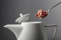 Dried rosebuds are poured into the teapot