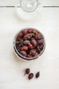 Dried rosehips in a jar on a light background, close-up