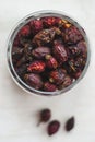 Dried rosehips in a jar on a light background, close-up