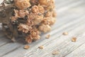 Dried roses on wooden table, vintage nostalgic still life in soft beige tones