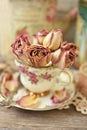 Dried roses in vintage style porcelain cup