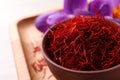 Dried saffron and crocus flowers on wooden tray, closeup. Space for text Royalty Free Stock Photo