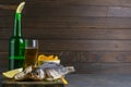 Dried salted crucian with beer, lemon and potato chips on dark wooden board. Snack on fish with beer. Front views with clear space Royalty Free Stock Photo