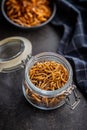 Dried salted worms. Roasted mealworms in jar on black table Royalty Free Stock Photo