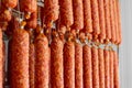 Dried sausage hanging on a rope on a metal frame in the smoke house.