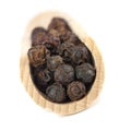 Dried seeds of black pepper on a wooden spatula. Royalty Free Stock Photo