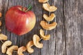 Dried sliced apple fruit with ripe fresh red apples on wooden rustic background