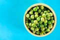 Dried Sugar Peas in wood bowl on blue background.top view Royalty Free Stock Photo