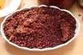 Dried sumac seasoning in a wooden bowl, top view. a handful of red sumac powder in a plate abstract background . Sumak grains and