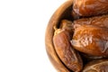 Dried of sweet dates palm fruits on wooden bowl on white background. Dates is a dried fruit that provides high energy Royalty Free Stock Photo