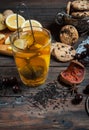 Dried tea with lemon and cookies on wooden table