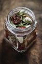 Dried tomatoes in a jar with fresh spices