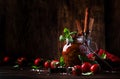 Dried tomatoes in olive oil with green basil and spices in glass jar on wooden kitchen table, rustic style, place for text Royalty Free Stock Photo