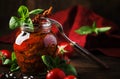 Dried tomatoes in olive oil with green basil and spices in glass jar on wooden kitchen table, rustic style, place for text Royalty Free Stock Photo