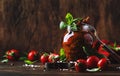 Dried tomatoes in olive oil with green basil and spices in glass jar on wooden kitchen table, rustic style, place for text Royalty Free Stock Photo