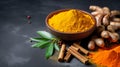 Dried turmeric powder with leaves on dark background. Curcuma powder in a wooden bowl with turmeric roots, cinnamon and green