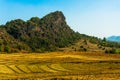 Dried up rice fields in front of rock formation
