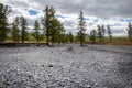 Dried up river bed in a rural countryside with the snowy mountains in the background. Majestic landscape with the rock road and Royalty Free Stock Photo