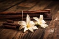 Dried vanilla pods and flowers on wooden background