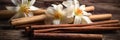 Dried vanilla pods and flowers on wooden background