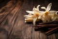 Dried vanilla pods and flowers on wooden background