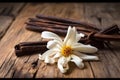 Dried vanilla pods and flowers on wooden background