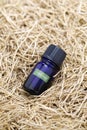 Dried vetiver roots and vetiver essential oil in a glass vial