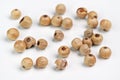 Dried white peppercorns isolated on white board, closeup detail