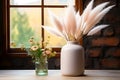 Dried white spikelets and grass flower in a white vase mock up on a wooden table decorated window Royalty Free Stock Photo