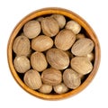 Dried whole nutmegs, fragrant or true nutmegs, in a wooden bowl