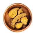 Dried whole turmeric root, dehydrated rhizomes in a wooden bowl Royalty Free Stock Photo