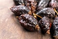 Dried wrinkled briar berries. Dry rose hips. Dog-rose fruits on a rustic wooden surface. Macro