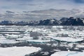 Drift Ice on Atlantic Ocean, Coastline with snow-capped Mountains in Background, Greenland