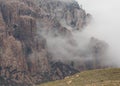 Drifting clouds partially conceal the mountain face.