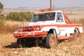 Drifting white Toyota Landcruiser truck kicking up dust on turn