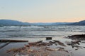 Driftwood on beach with sunset over mountains background Royalty Free Stock Photo