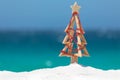 Driftwood Christmas tree decorated with string of red baubles at Royalty Free Stock Photo