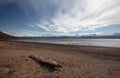 Driftwood log under dramatic sky at the head of the Kachemak bay near Homer Alaska USA Royalty Free Stock Photo