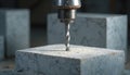 Drill bit drills grey stone block. Stone dust surrounds drill hole. Rotary tool bores into solid material. Closeup view of Royalty Free Stock Photo