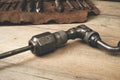 Drill brace with bits in leather tool roll on a wooden workbench Royalty Free Stock Photo