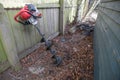 Drill like excavation hole digger power tool leaning against a fence waiting to be used to dig fence post holes Royalty Free Stock Photo