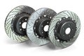 Drilled and slotted brake disks in a row. Different types of brake disks