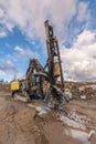 Drilling machine in a construction site surrounded by rock and mud Royalty Free Stock Photo