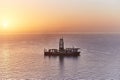 Drilling ship drilling oil well bottom ocean shelf. Geological exploration gas and oil fields in sea at sunset